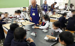 関西本部:理科分科会:雲雀丘学園小学校 「やってみなはれ塾」理科体験教室 水の電気分解といろいろな電池 初めて触る一人一人の実験装置、興味深げに眺めている